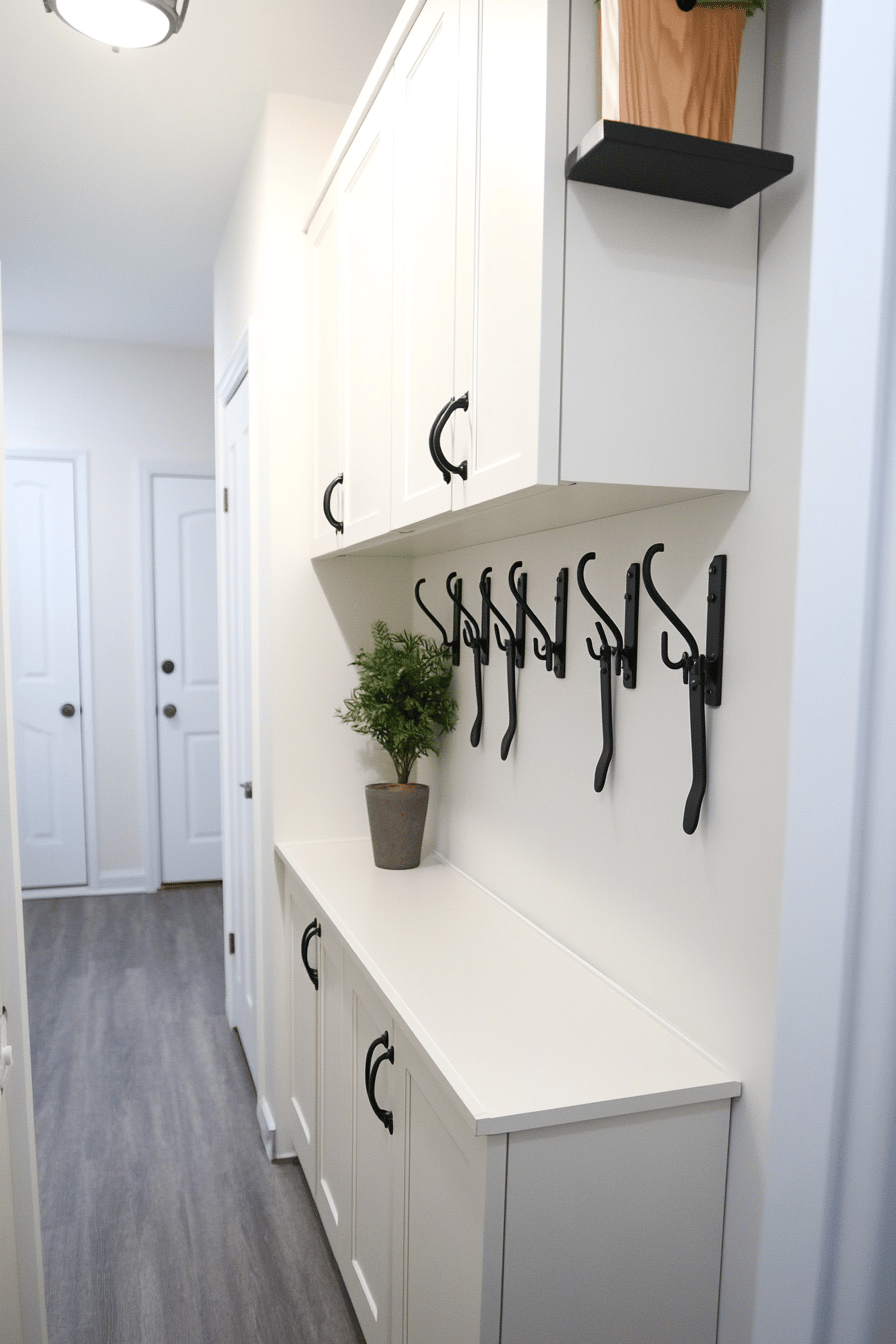 Heller Flur mit weißen Schränken und schwarzen Haken an der Wand.
