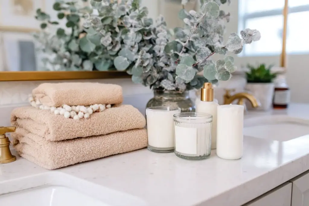 Winterliche Badezimmerdekoration mit Handtüchern, Kerzen und Eukalyptuszweigen