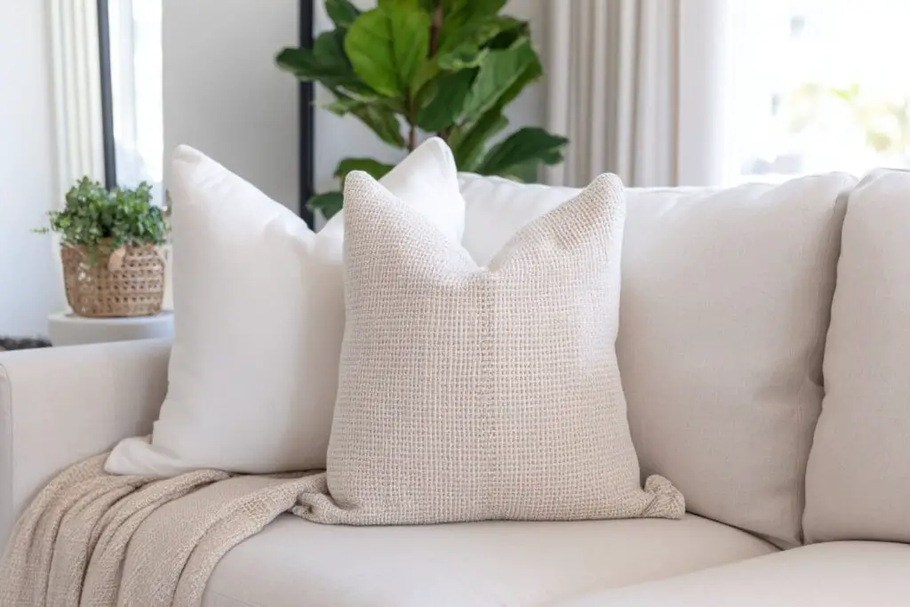 Beige Kissen auf heller Couch im modernen Wohnzimmer