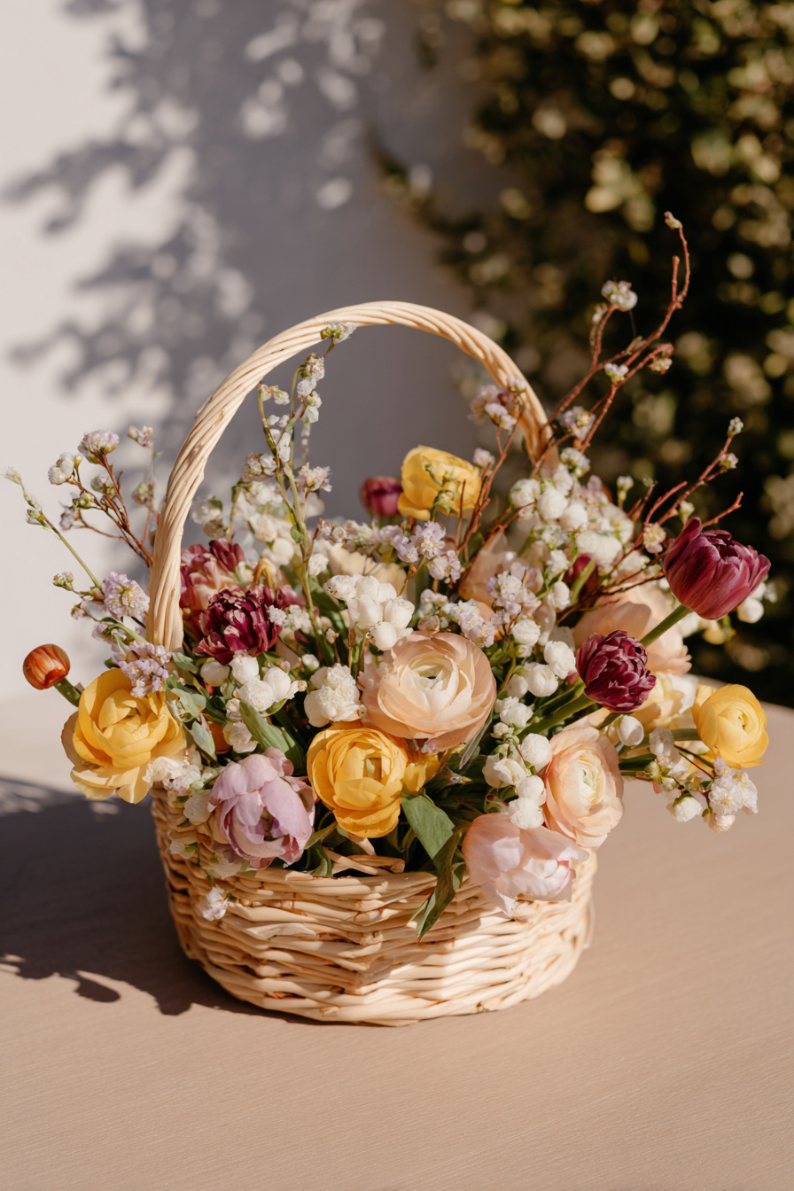 Weidenkörbchen mit Frühlingsblumen und Zweigen