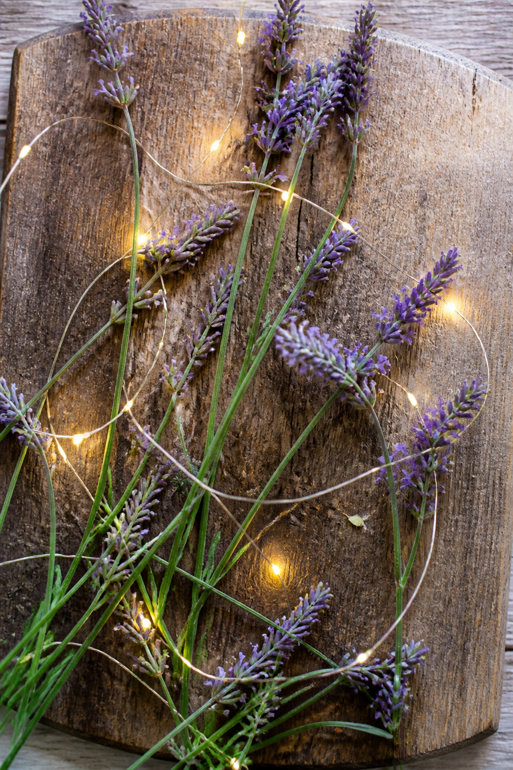 Holzbrett mit Lavendel und Lichterkette als Tischdeko