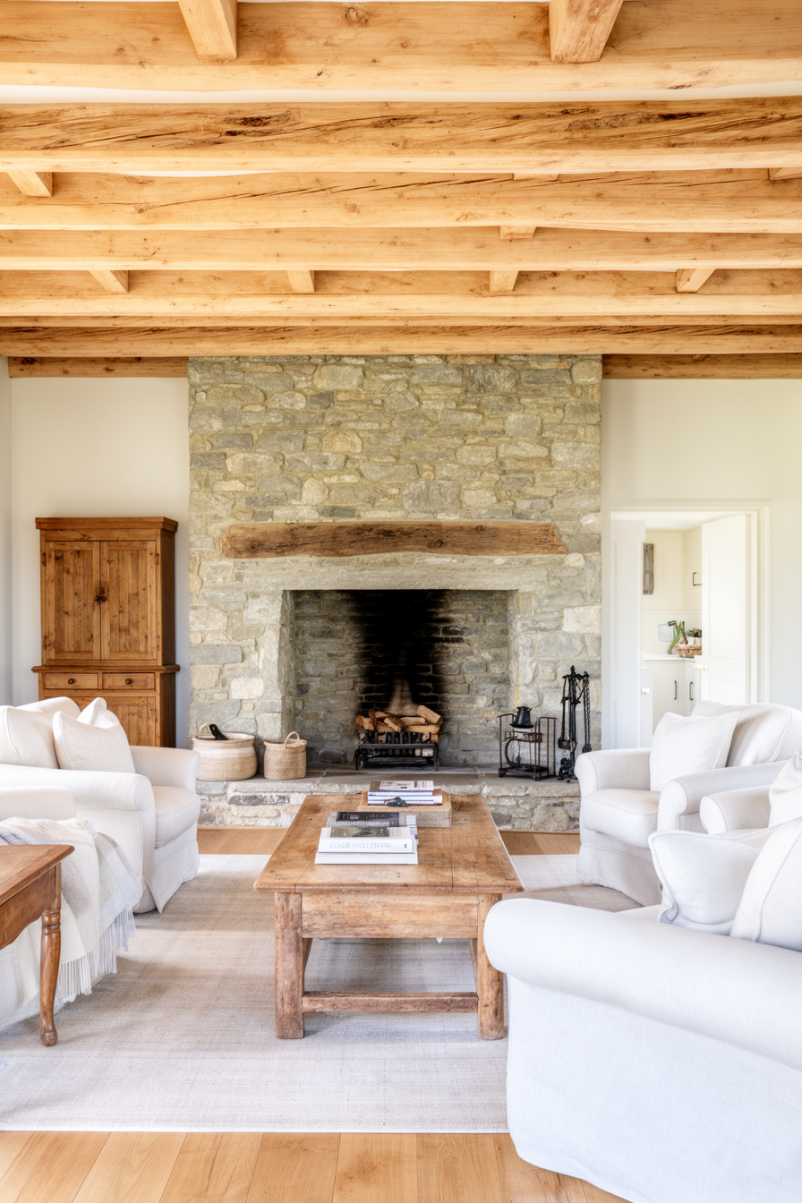 Wohnzimmer mit Holzbalken und Kamin im Landhausstil