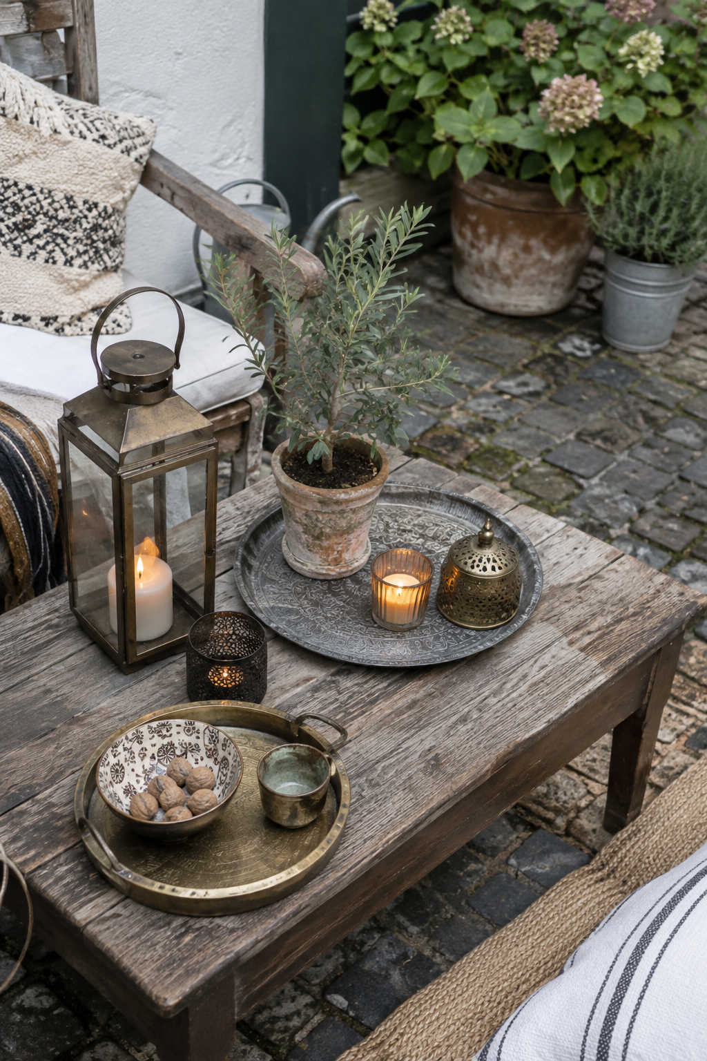 Niedriger Holztisch mit Laternen und Textilien