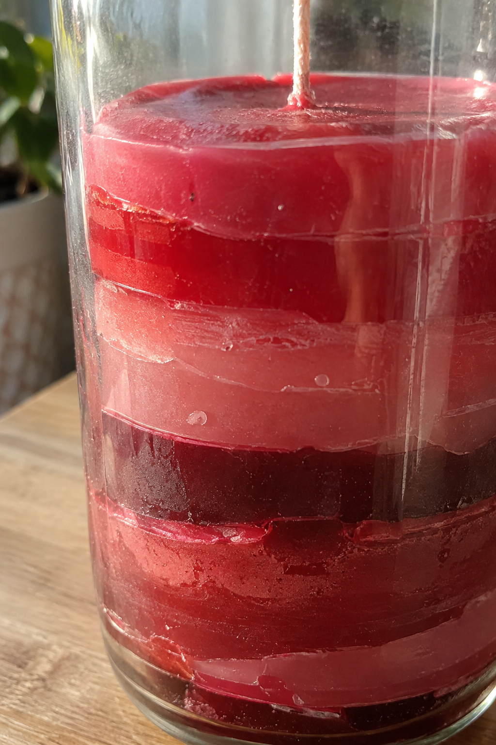 Nahaufnahme roter Schichtkerze im Glas